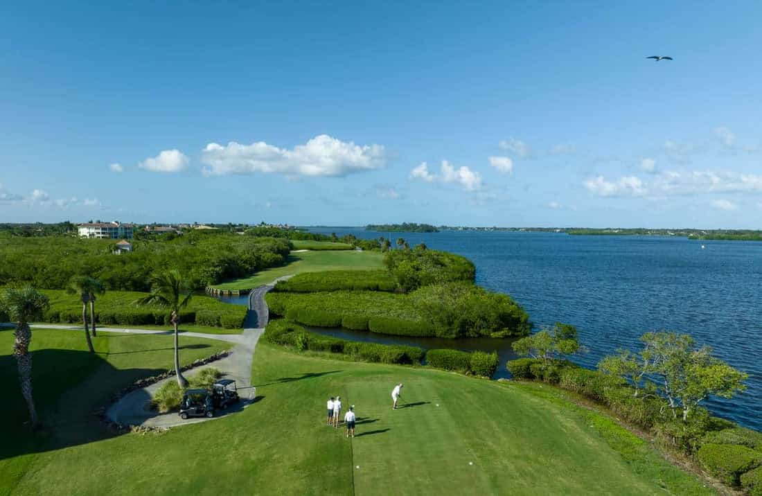 Aerial drone footage of luxury golf course and Indian River waterfront in Vero Beach — establishing context for remote luxury buyers
